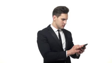Genç hadnsome işadamı yazarak mobil beyaz arka plan üzerinde izole ciddi yüz ifadesi ile.