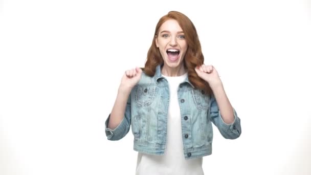 Portrait surprised ginger woman in denim shirt looking at the camera over white background — Stock Video