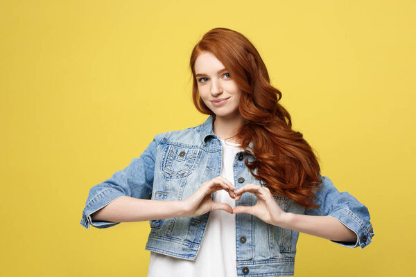 Lifestyle Concept: Beautiful attractive woman in denim making a heart symbol with her hands