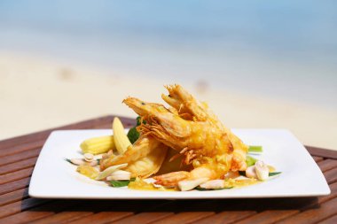 Kızarmış karides dekorasyon sebze plaj manzarası ile ahşap masa üzerinde üzerinde