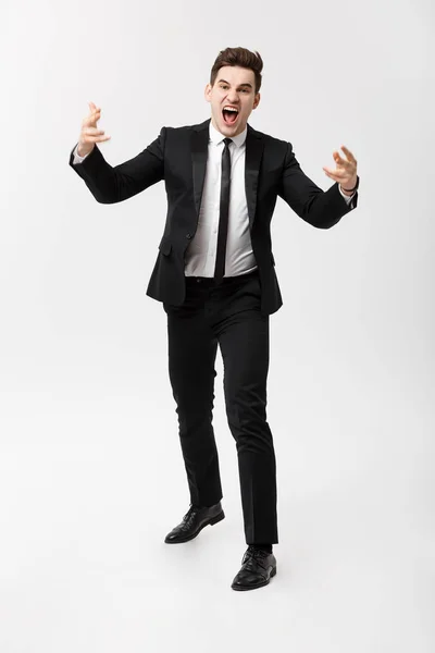 Business Concept: Full-length Portrait of a mad businessman in suit yelling and screaming while standing over isolated gray background. — Stock Photo, Image