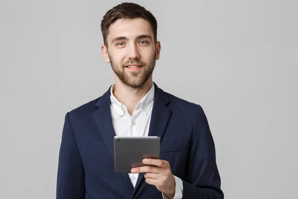 Geschäftskonzept - Porträt schöner Geschäftsmann spielt digitales Tablet mit lächelndem selbstbewusstem Gesicht. weißer Hintergrund. Kopierraum. — Stockfoto