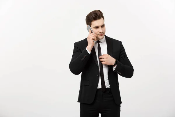 Concepto de negocio: Hombre de negocios guapo en traje y hablando por teléfono sobre un fondo gris aislado . —  Fotos de Stock