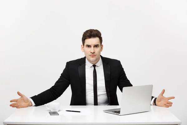 ビジネス コンセプト: 青年実業家の明るいオフィスで、机に座って作業深刻な表情でノート パソコンを使用して — ストック写真