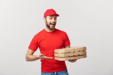 : Teslimat pizza kutuları gri arka plan üzerinde izole tutan genç beyaz yakışıklı Pizza teslim adam kavramı
