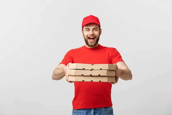 Concepto de entrega: Joven caucásico guapo repartidor de pizza hombre sosteniendo cajas de pizza aisladas sobre fondo gris —  Fotos de Stock