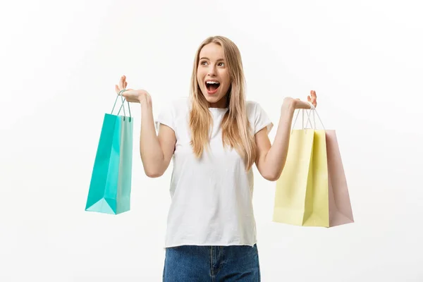 Lifestylekonzept: Porträt schockiert junge brünette Frau in weißem Sommerhemd posiert mit Einkaufstaschen isoliert über weißem Hintergrund. — Stockfoto