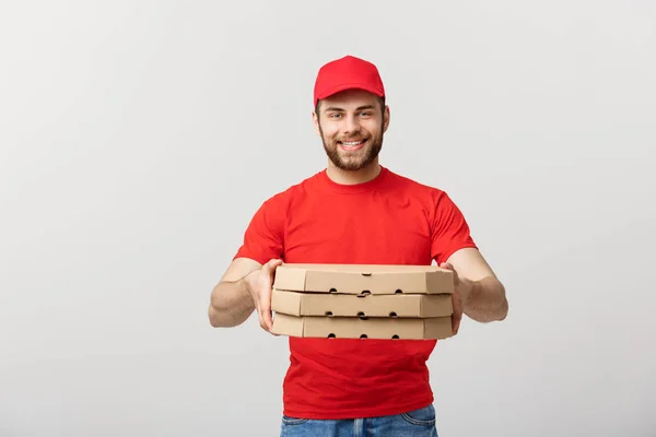 Concepto de entrega: Joven caucásico guapo repartidor de pizza hombre sosteniendo cajas de pizza aisladas sobre fondo gris —  Fotos de Stock