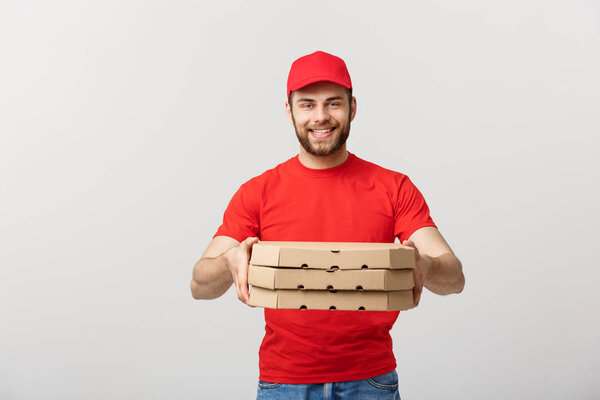 Delivery Concept: Young caucasian Handsome Pizza delivery man holding pizza boxes isolated over grey background