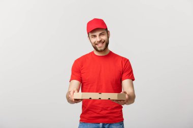 Yakışıklı delikanlı gri arka plan üzerinde izole pizza teslim.