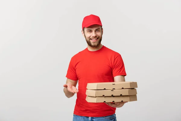 Lieferkonzept: junger kaukasischer Pizzabote mit Pizzakartons vor grauem Hintergrund — Stockfoto