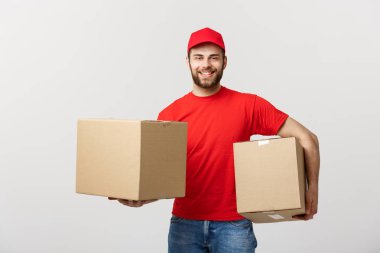 : Teslimat bir kağıt kutusu tutarak gülümseyen yakışıklı beyaz teslimat adam kavramı. Gri arka plan üzerinde izole.