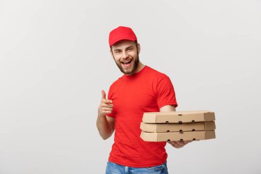 Teslimat kavramı: Yakışıklı beyaz Pizza teslimi adam işaret parmağı. Gri arka plan üzerinde izole.