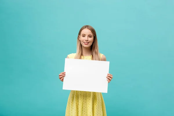 Portrait beautiful young caucasian woman holding a blank paper isolated on pastel blue background — Stock Photo, Image