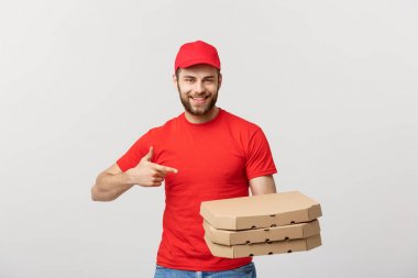 Teslimat kavramı: Yakışıklı beyaz Pizza teslimi adam işaret parmağı. Gri arka plan üzerinde izole.