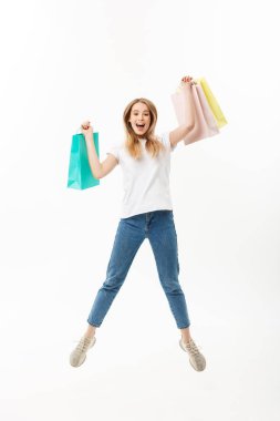 Mutlu bir güzel kız alışveriş torbaları atlama ve beyaz arka plan üzerinde izole kamera bakarak süre tutarak tam uzunlukta portresi