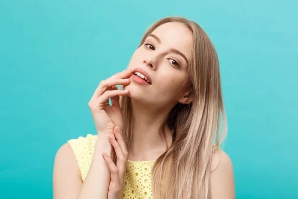 Bela Mulher Face Retrato Beleza Cuidados com a Pele Conceito: beleza jovem caucasiano fêmea modelo menina tocando seu rosto pele bochechas mãos dedos. Modelo de beleza de moda isolado em azul . — Fotografia de Stock