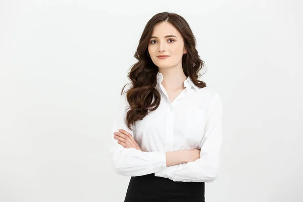 Businss Concept: Retrato confiado joven empresaria manteniendo los brazos cruzados y mirando a la cámara mientras está de pie sobre un fondo gris — Foto de Stock