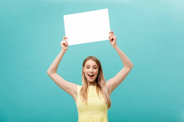 Retrato bela jovem caucasiana segurando um papel em branco isolado no fundo azul pastel — Fotografia de Stock