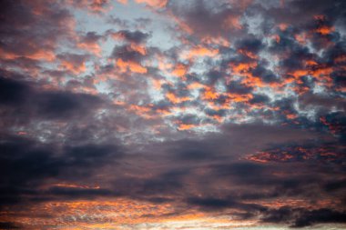 Karanlık ve dramatik fırtına bulutları içinde kırmızı güneş ışığı.