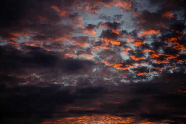 Rotes Sonnenlicht in den dunklen und dramatischen Gewitterwolken. — Stockfoto