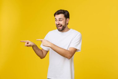 Sarı arkaplanda izole edilmiş kopya alanı gösteren bir adam. Sıradan yakışıklı Kafkasyalı genç adam..