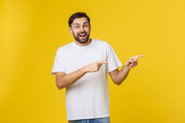 Sarı arkaplanda izole edilmiş kopya alanı gösteren bir adam. Sıradan yakışıklı Kafkasyalı genç adam..