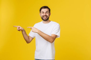 Sarı arkaplanda izole edilmiş kopya alanı gösteren bir adam. Sıradan yakışıklı Kafkasyalı genç adam..