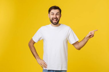 Sarı arkaplanda izole edilmiş kopya alanı gösteren bir adam. Sıradan yakışıklı Kafkasyalı genç adam..