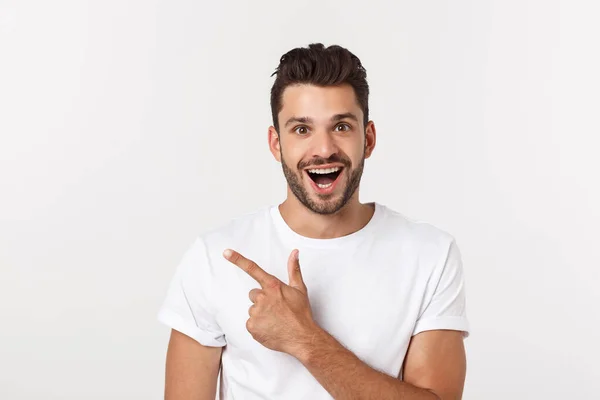 Man pointing showing copy space isolated on white background. Casual handsome Caucasian young man. — Stock Photo, Image