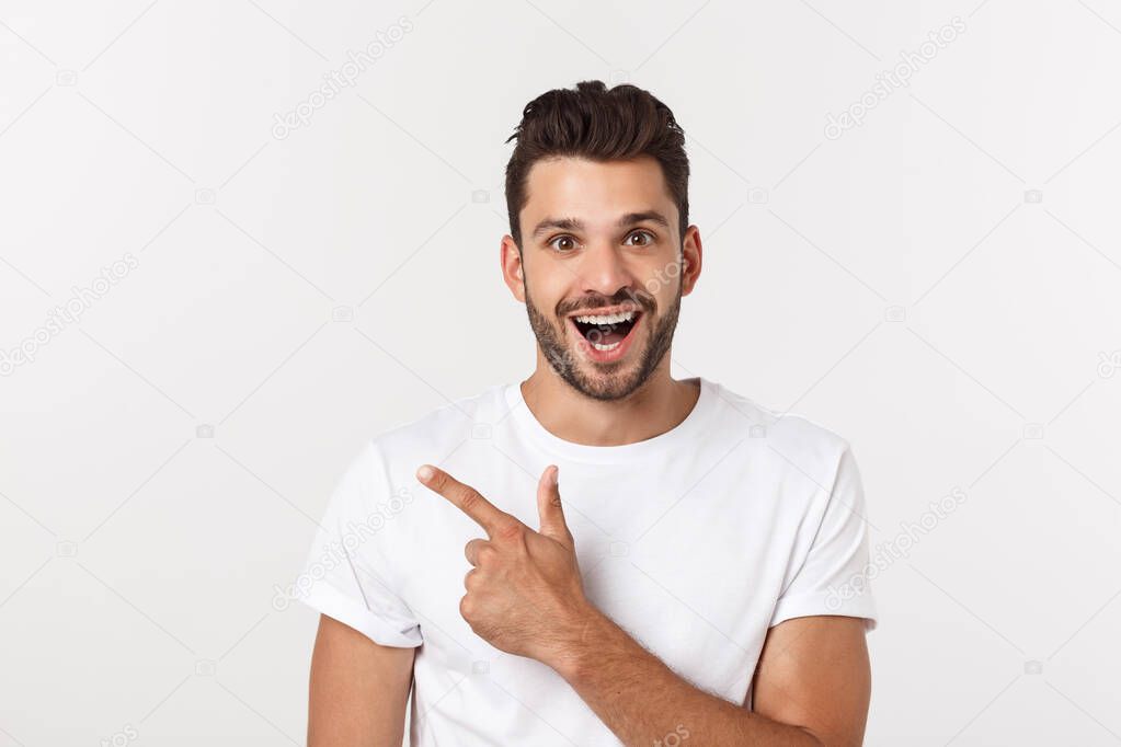 Man pointing showing copy space isolated on white background. Casual handsome Caucasian young man.