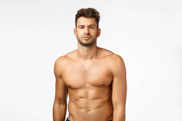 Waist-up shot confident good-looking, sexy young tanned man, athlete standing naked torso, squint, showing six-pack perfect body, train in gym, workout daily, lead active lifestyle. Bodybuilder promo — ストック写真