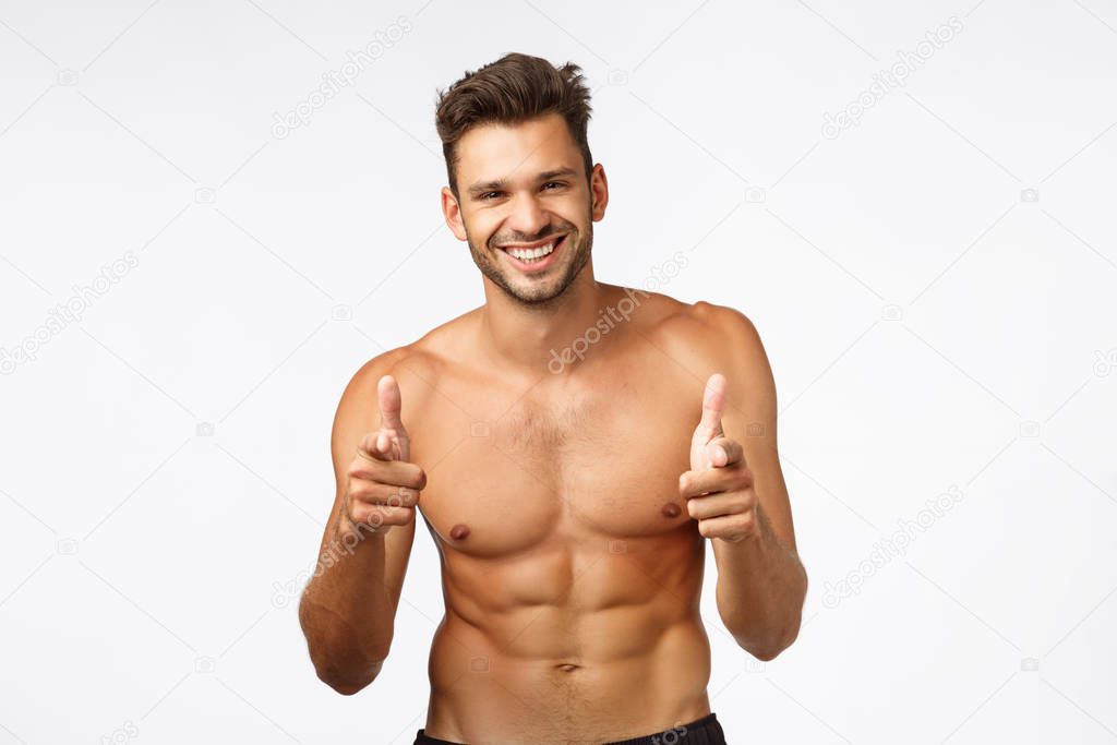 Handsome charming bearded young guy with naked torso, perfect body six-pack, finish workout, thanking instructor, show thumbs-up and smiling in approval, give positive feedback about gym, exercises