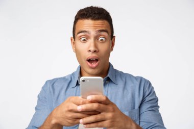 Şok olmuş ve etkilenmiş yakışıklı adam suskun bir şekilde dikiliyordu. Akıllı telefondan arkadaşlarının parti videosunu izliyordu. Mobil ekranı patlak gözlerle izliyordu.