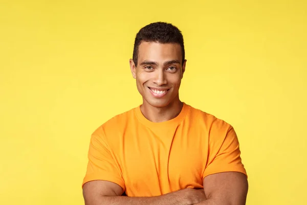 Homem masculino confiante e atrevido em t-shirt, cruz braços peito postura auto-confiante, sorrindo como não tem dúvidas pode ganhar, assertivo e satisfeito de pé fundo amarelo, compartilhar notícias interessantes — Fotografia de Stock