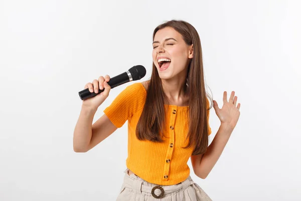 Joven bonita mujer feliz y motivada, cantando una canción con un micrófono, presentando un evento o haciendo una fiesta, disfruta del momento —  Fotos de Stock