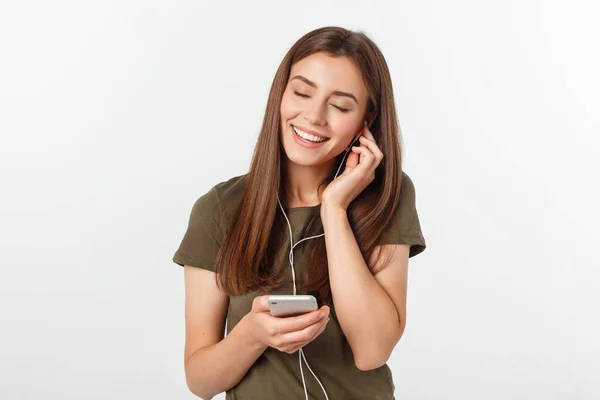 Retrato de una linda mujer alegre escuchando música en auriculares y bailando aislada sobre un fondo blanco . — Foto de Stock