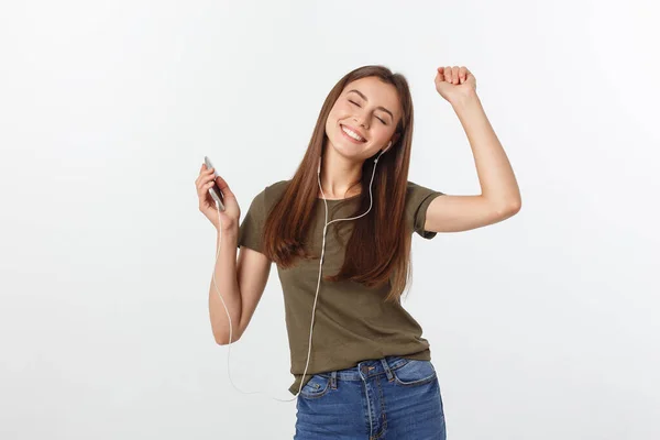 Retrato de una linda mujer alegre escuchando música en auriculares y bailando aislada sobre un fondo blanco . — Foto de Stock