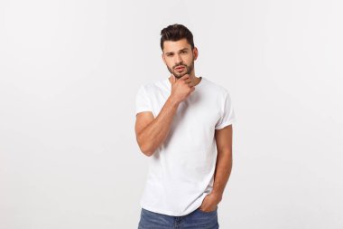 Beyaz arka planda izole edilmiş beyaz tişörtlü gülümseyen genç adam portresi.