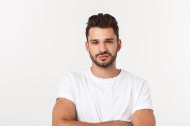 Beyaz arka planda izole edilmiş beyaz tişörtlü gülümseyen genç adam portresi.
