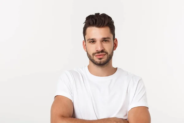 Portret van een lachende jongeman in een wit t-shirt geïsoleerd op witte achtergrond. — Stockfoto