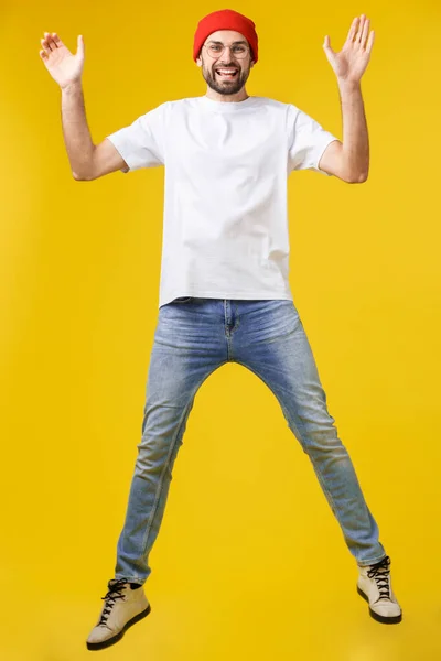 Νεαρός casual άνθρωπος άλμα για τη χαρά σε κίτρινο χρυσό φόντο — Φωτογραφία Αρχείου