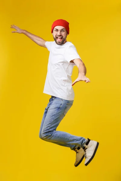 Mladý ležérní muž skákání pro radost na žlutém zlatém pozadí — Stock fotografie
