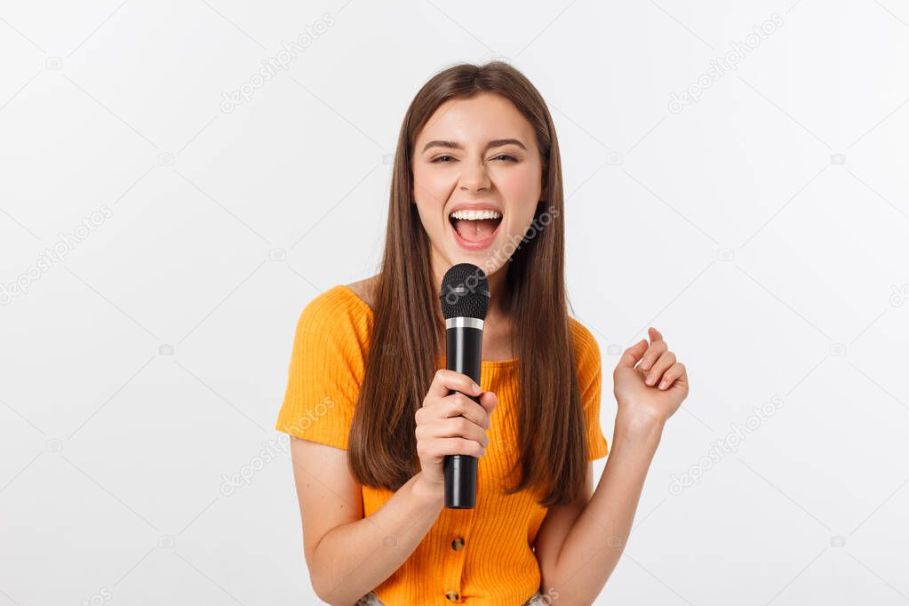 Young pretty woman happy and motivated, singing a song with a microphone, presenting an event or having a party, enjoy the moment