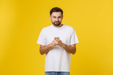 Telefonda konuşan ciddi bir adamın portresi sarı arka planda izole edilmiş. Kameraya bakıyorum.