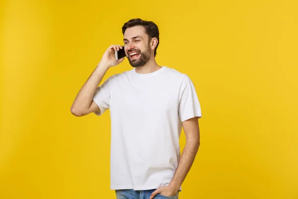 Jong casual man praten op de telefoon geïsoleerd op gele achtergrond — Stockfoto