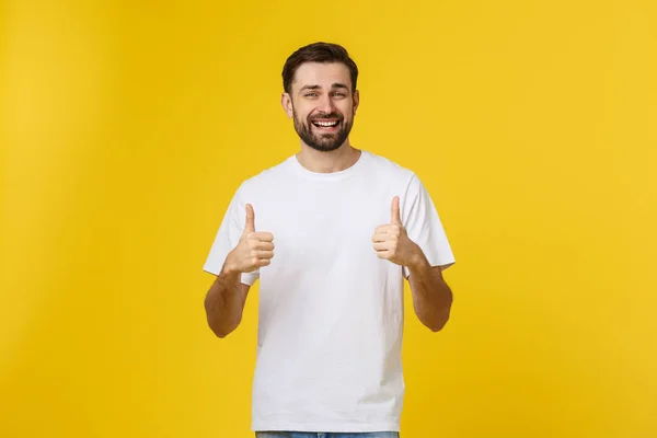 Jong gelukkig man met duimen omhoog teken in casuals geïsoleerd op gele achtergrond — Stockfoto