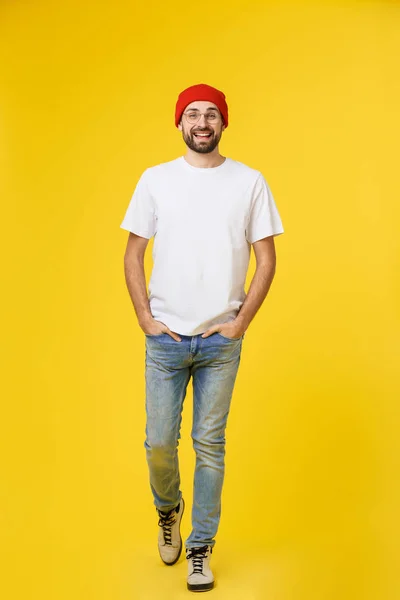 Νεαρός hipster άντρας φορώντας καπέλο, τιράντες, απομονώνονται σε κίτρινο φόντο. — Φωτογραφία Αρχείου