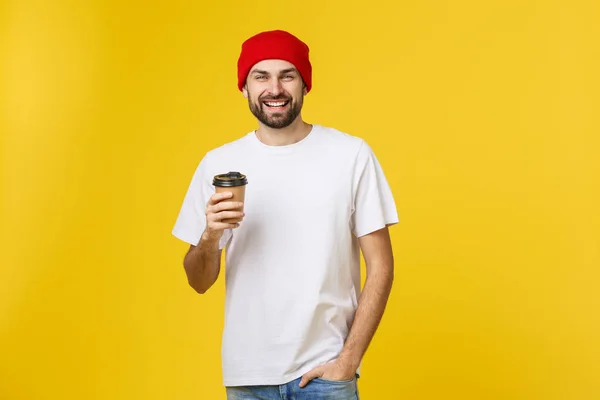 Man op geïsoleerde levendige gele kleur, een kopje koffie nemen in afhaalmaaltijden papier beker en glimlachend omdat hij zal begin de dag goed. — Stockfoto