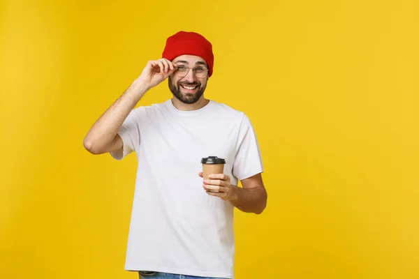 Man op geïsoleerde levendige gele kleur, een kopje koffie nemen in afhaalmaaltijden papier beker en glimlachend omdat hij zal begin de dag goed. — Stockfoto